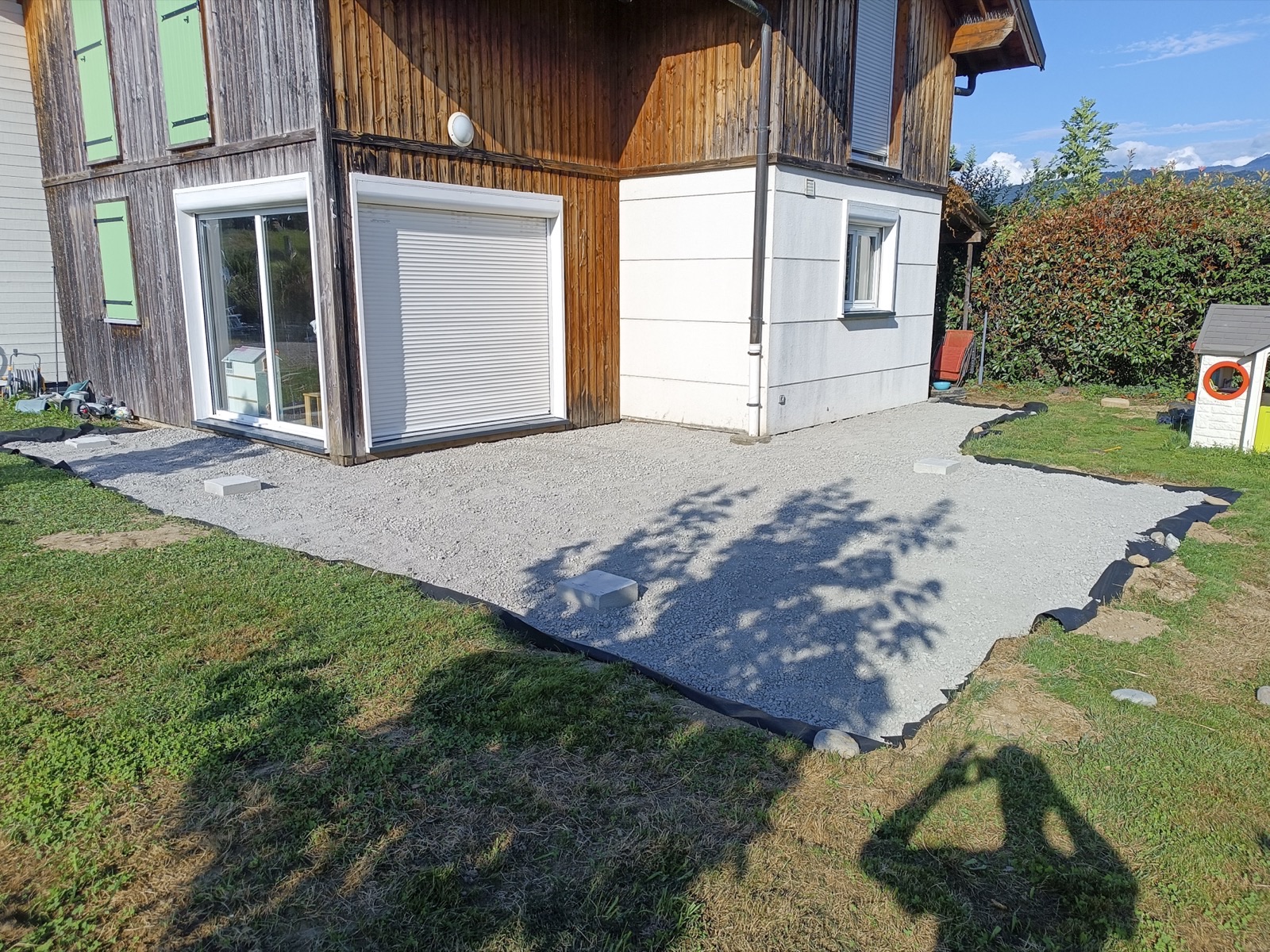 Terrain préparé avant pose d'une terrasse bois devant un chalet, Savoie