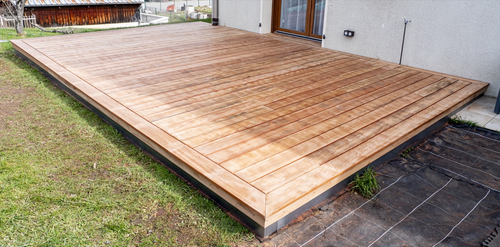 Terrasse bois lames rasantes posées à niveau, jardin en Savoie