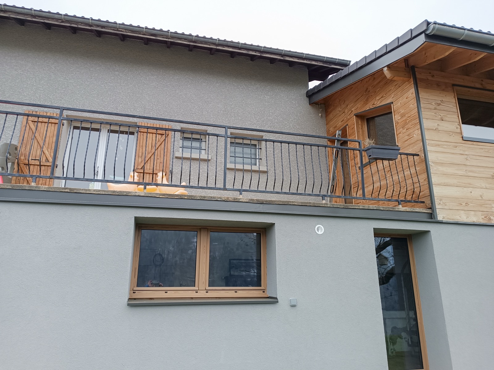 Façade rénovée avec garde-corps métal et bardage bois, Savoie