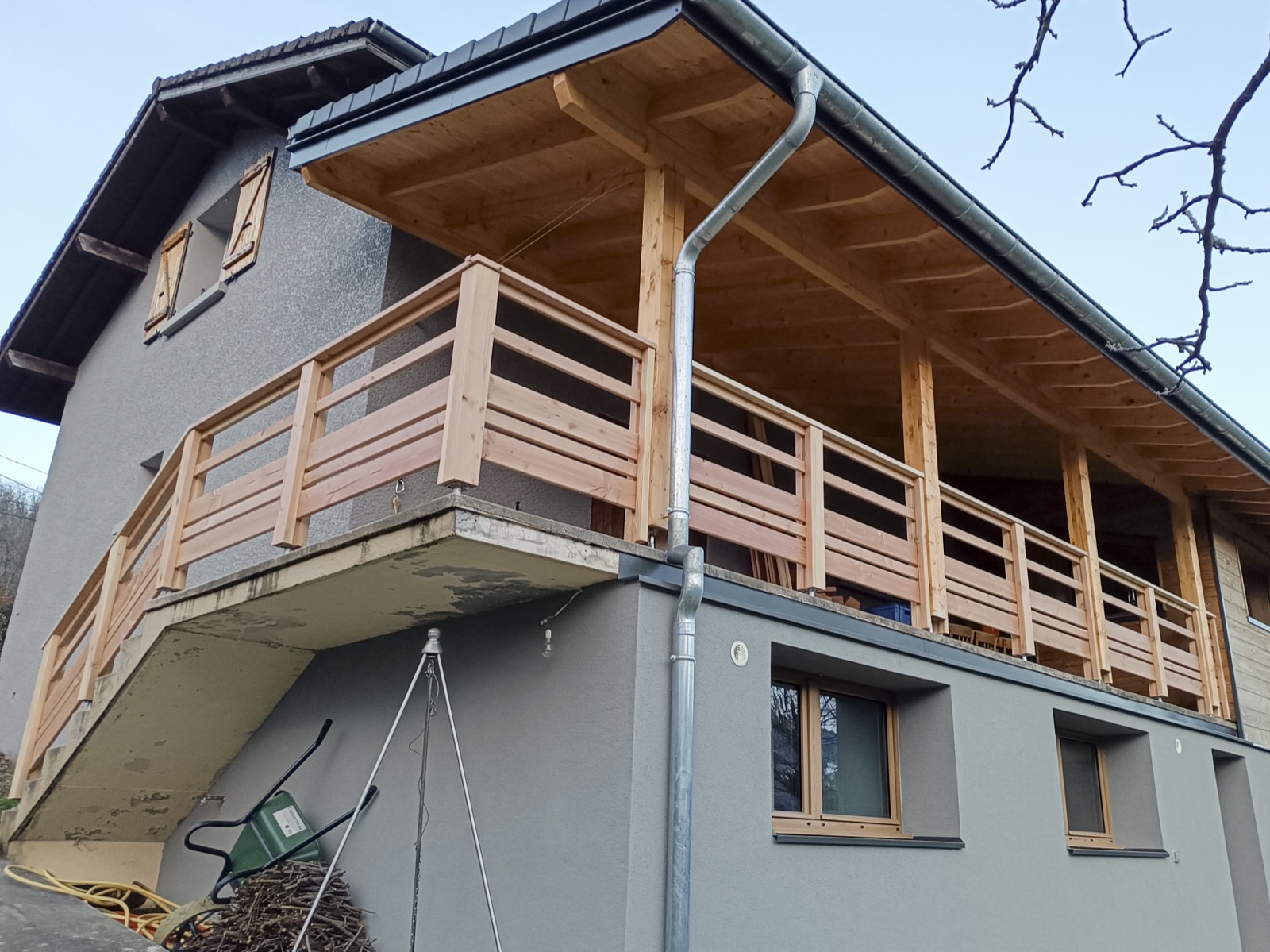 Balcon et charpente bois sur maison en Savoie, garde-corps et gouttière zinc