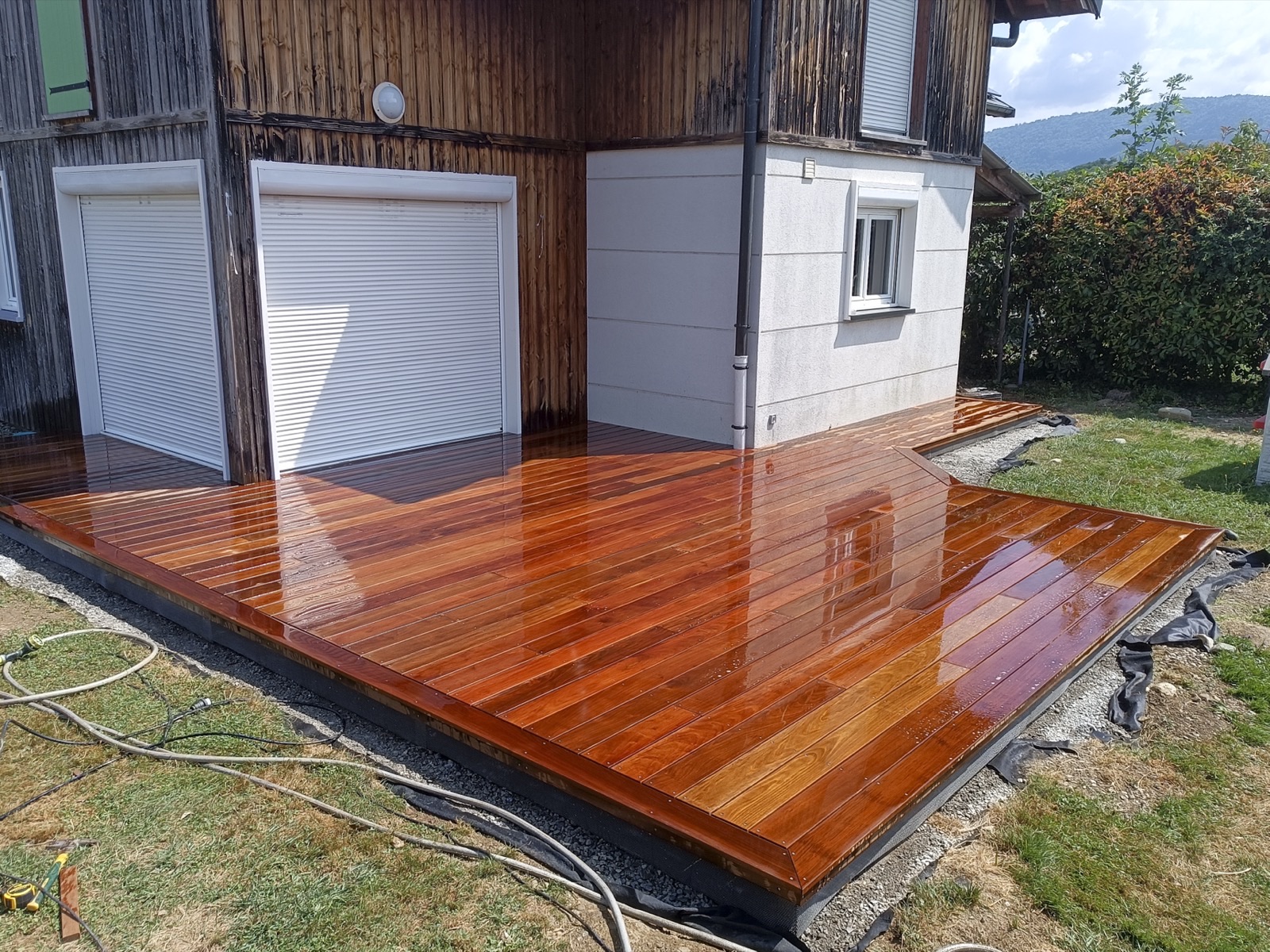 Terrasse en bois massif huilé devant une maison en Savoie